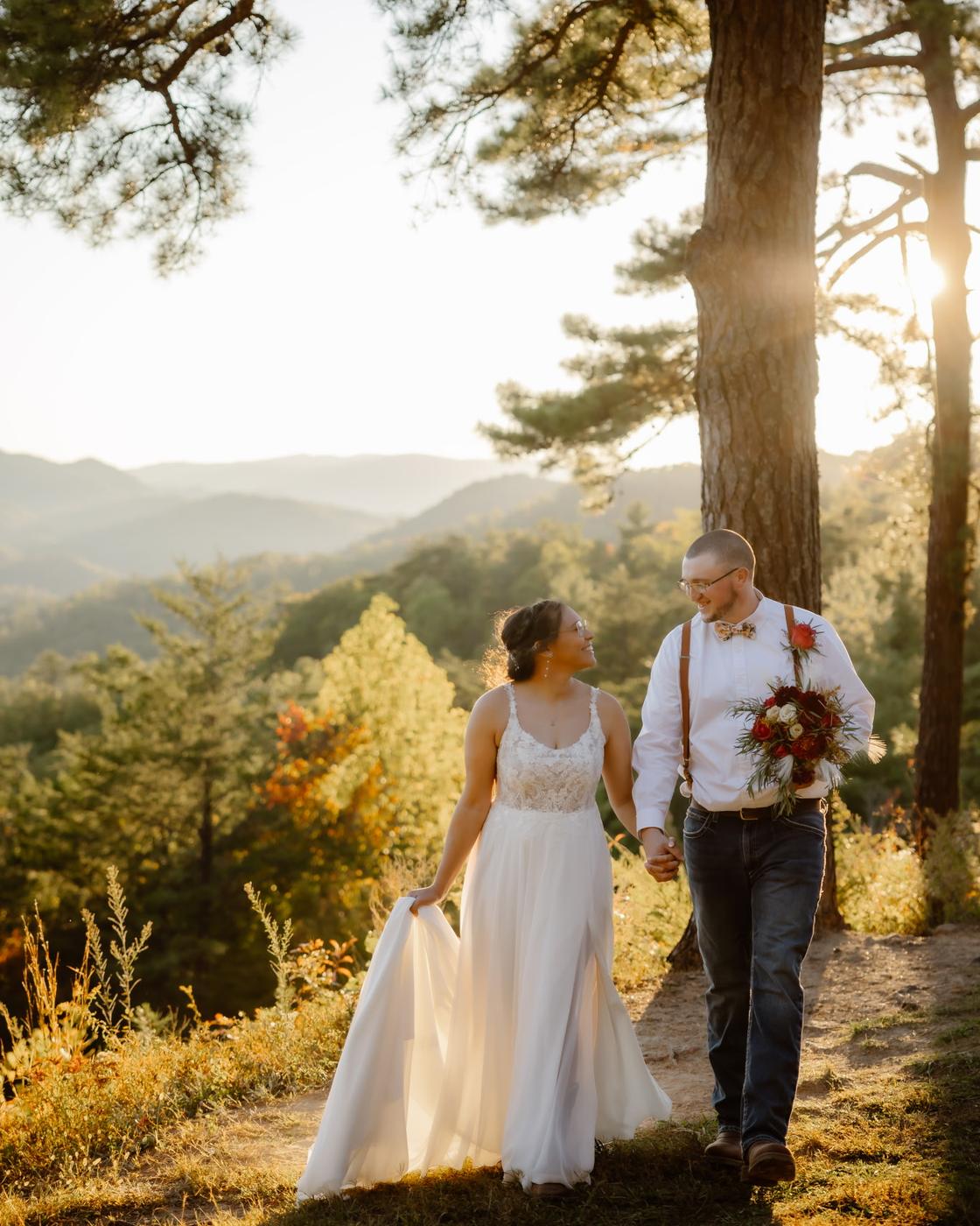 A'leigha and her husband walking hand in hand through the mountains on their wedding day